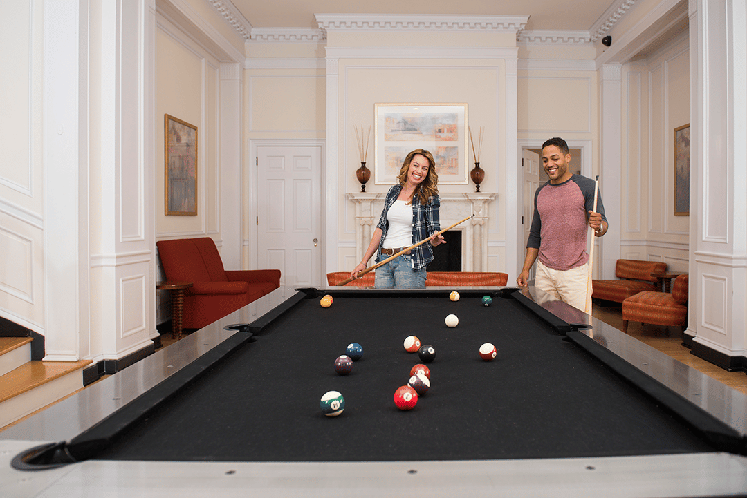 couple playing pool at lounge in apartments in wilmington de